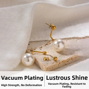 Détail de boucles d'oreilles géométriques en acier doré 18K avec perles crème