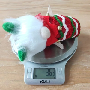 Détail d'un gnome de Noël rayé pesant 36,3 g sur une balance pour les spécifications