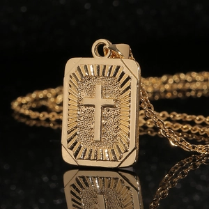 Polished gold rectangular cross pendant necklace with radiant texture on black background