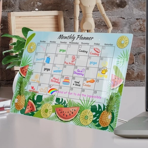 Close-up of acrylic monthly planner featuring tropical pineapple and watermelon patterns