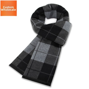 Détail du motif à carreaux noir et gris classique et des fines franges sur l'écharpe