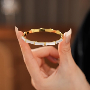 Macro detail of gold-plated bamboo joint bracelet featuring white mother of pearl inlay