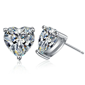 Sparkling heart-shaped zircon stud earrings with silver three-prong setting on white background