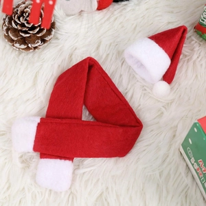 Mini Christmas hat and scarf set for wine bottle decor on plush background with pine cones