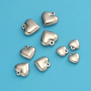 Polished heart-shaped stainless steel charms in various sizes on a blue surface