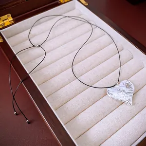 Minimalist heart pendant necklace with hammered silver finish on black cord chain