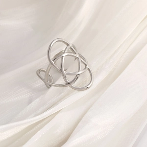 Macro shot of a vintage silver irregular knot ring on elegant white silk fabric