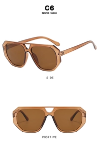 Close-up of retro double-bridge sunglasses with amber frames and brown lenses