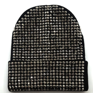 Bonnet en maille acrylique noire pour l'hiver avec strass argentés brillants sur fond blanc