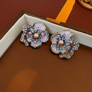 Detailed view of vintage floral earrings with pink enamel and pearls in a jewelry box