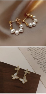 Close-up of elegant pearl hoop earrings and mother-of-pearl butterfly studs with gold finish