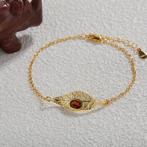 Macro shot of S925 silver gold leaf bracelet with oval red garnet stone detail