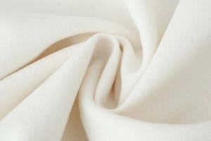 Macro detail of soft white wool fabric with thick texture for women's winter coat