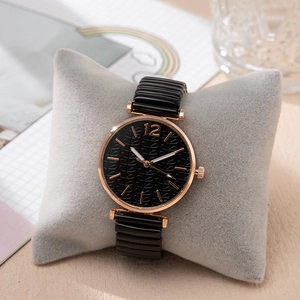 Dettaglio di un orologio con quadrante nero testurizzato, cassa in oro rosa e cinturino