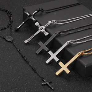 Collection of black, gold, and silver titanium cross necklaces with crystal accents