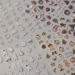 Détail de stickers à ongles de Noël avec relief doré 3D, rennes et flocons de neige