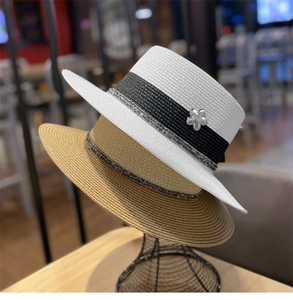 Dettaglio di cappelli di paglia a testa piatta con paillettes e fiori decorativi