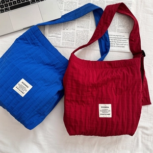Close-up of quilted fabric texture and logo label on a large capacity shoulder bag