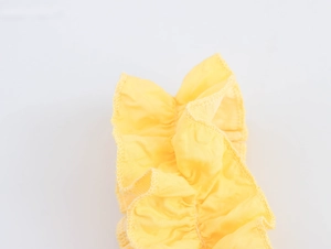 Detail shot of yellow textured bubble fabric strap with ruffled edges for summer dress