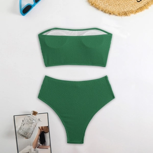 Flat lay of green two-piece bikini with textured fabric and high-waisted bottoms