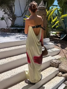 Back view of backless satin maxi dress in beige with red print and black buckle detail