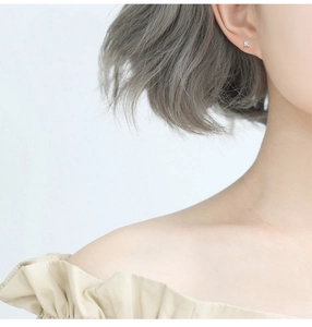Minimalist square zircon stud earring in silver worn by a model to show size and style