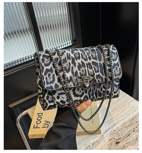 Detailansicht der schwarz-weißen Leoparden-Tasche mit Silberkette und Metallnieten