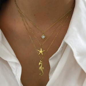 Collier doré à trois rangs avec pendentifs étoile de mer et hippocampe sur mannequin