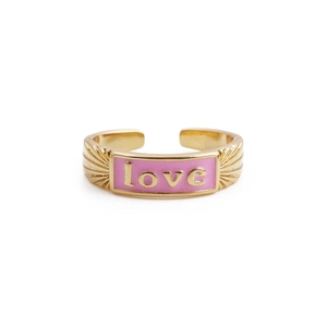 Detailed close-up of golden ring featuring pink enamel inlay and love letter carving