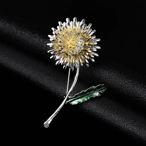 Détail de la broche pissenlit avec pétales dorés, feuille verte et petit strass