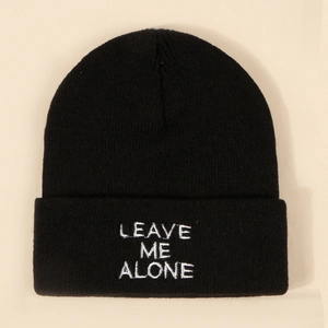 Classic black knitted beanie featuring white Leave Me Alone embroidery on a folded cuff