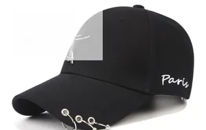 Detail of black punk baseball cap with Paris embroidery, metal rings and Eiffel Tower charm