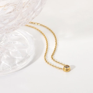 Minimalist 18K gold plated stainless steel necklace with a round zircon pendant on white