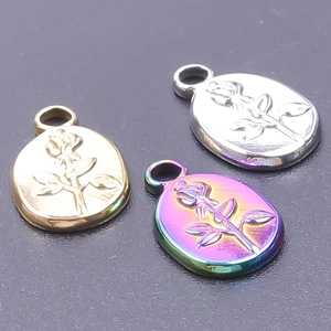 Detailed macro view of oval rose embossed pendants in gold, silver and rainbow metal finish