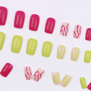 Neon pink and green press-on nails with wave patterns on a clean white background