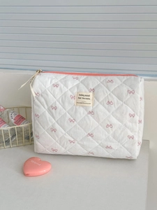 Trousse à maquillage matelassée crème avec motifs nœuds roses et fermeture zippée