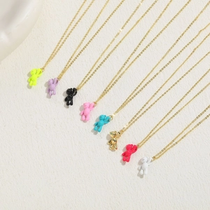 Close-up of colorful bear pendant necklaces in eight vibrant glossy finishes on gold chains