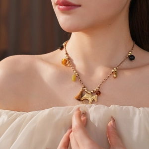 Detail of woven horse pendant necklace with colorful beads on model neck