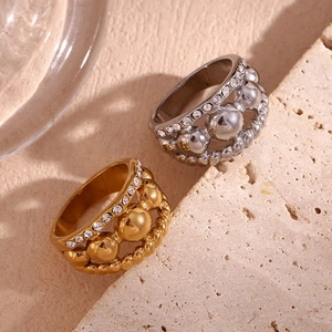 Close-up of 18K gold and silver layered rings with crystals on a stone plate