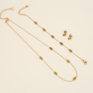 Close-up of golden Hamsa Hand jewelry set with Evil Eye and S.STEEL engraved detail