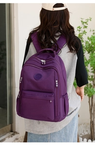Rear view of purple nylon backpack with multiple compartments and a minimalist logo