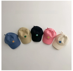 Détail de cinq casquettes de baseball pour enfants avec de petits motifs floraux brodés