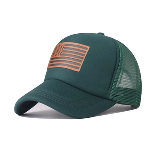 Detail of dark green trucker hat featuring US flag patch and breathable mesh back