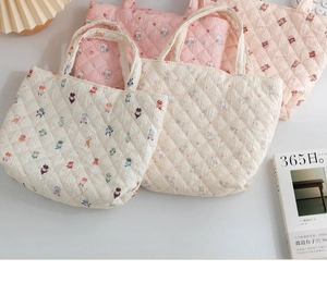 Quilted tote bags with colorful animal patterns in pink and beige on textured fabric