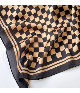 Detailed view of the checkered silk scarf fabric showing smooth texture and pattern