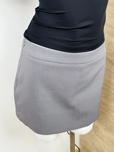 Detail shot of a grey A-line mini skirt on a mannequin showing fit and fabric texture