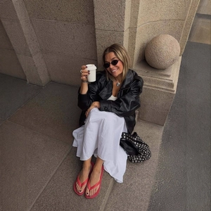 Giacca chic in pelle PU nera con abito bianco e infradito rosse alla moda