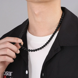 Detail of men's black beaded necklace featuring polished 6-8mm round stone beads
