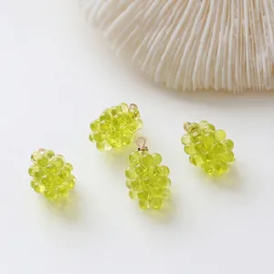 Detailed view of four translucent green resin grape pendants with gold metal ring hooks
