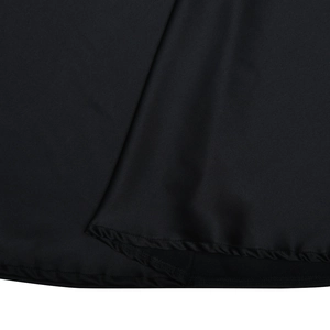 Close-up of the black dress hemline featuring neat stitching and fabric pleats detail